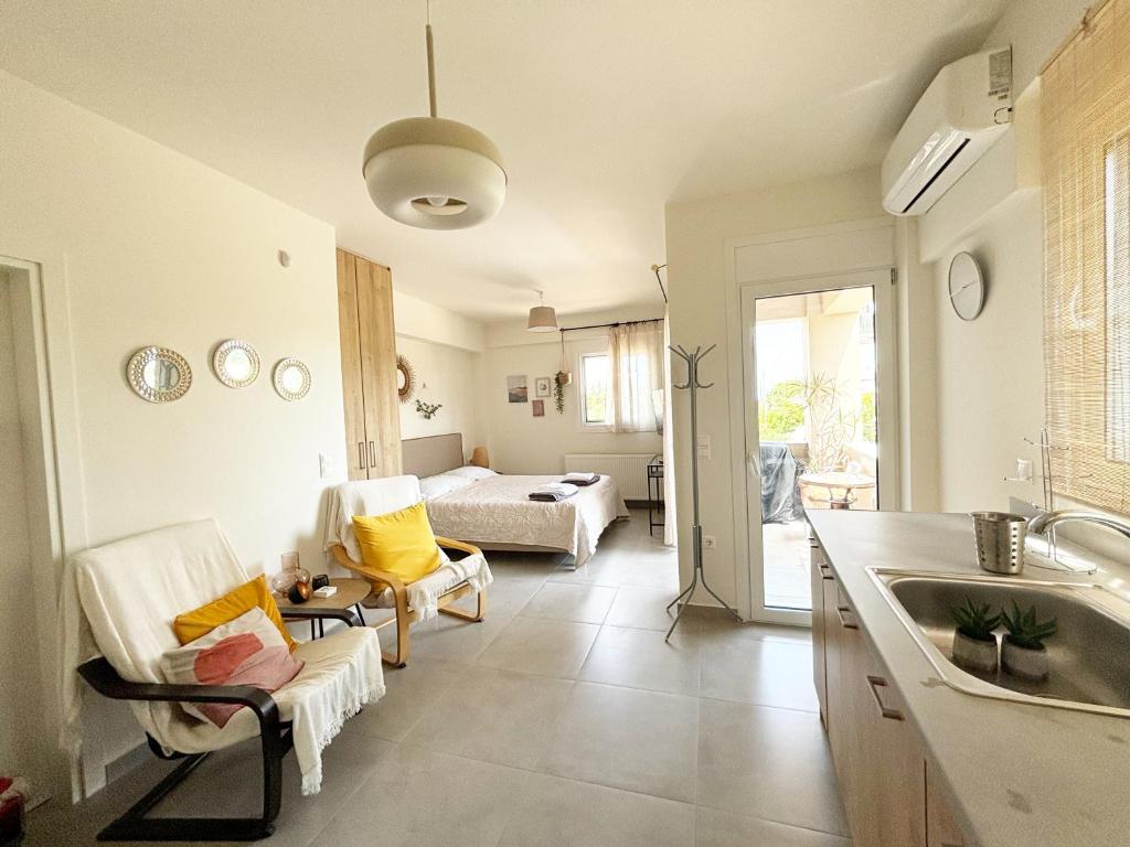 uma cozinha com um lavatório e uma sala de estar em Liakada Guest House em Artemida