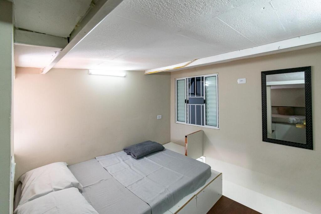 ein kleines Schlafzimmer mit einem Bett und einem Fenster in der Unterkunft 53 LOFT Quadruplo · LOFT 900m da São Paulo Expo e do metrô Jabaguara in São Paulo