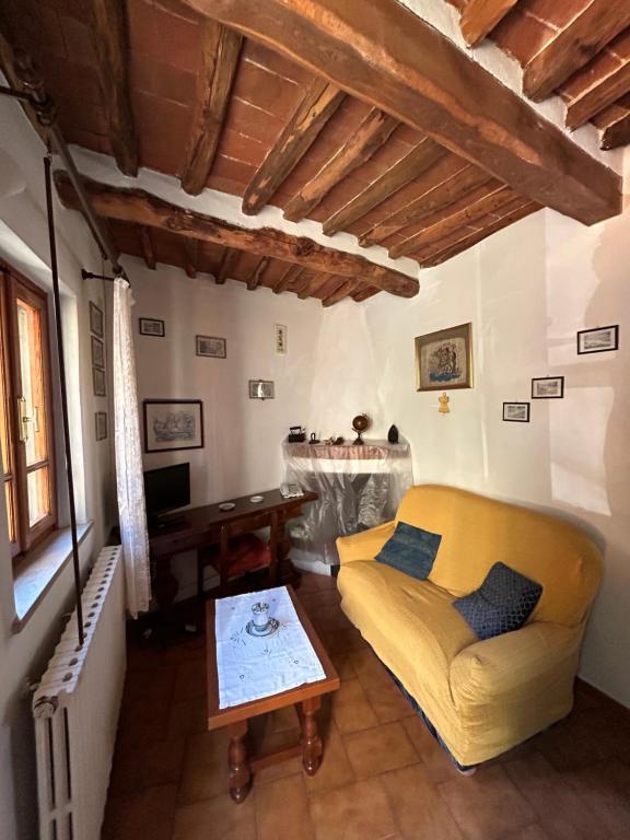ein Wohnzimmer mit einem gelben Sofa und einem Tisch in der Unterkunft Da Giovannina in Buti