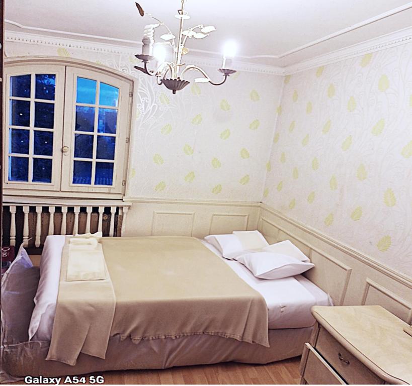 um quarto com uma cama e um lustre em Jolie demeure proche stade de France em Drancy