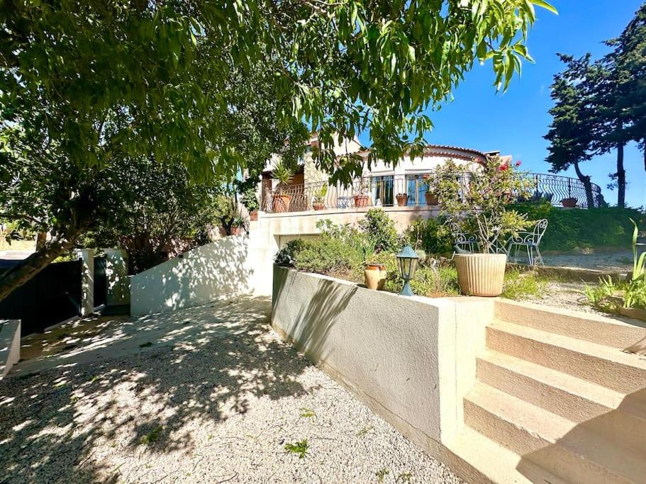 a house with a staircase in front of a tree at VILLA ENTIÈRE PORT et PLAGE BANDOL in Bandol