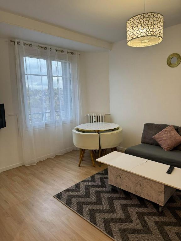 a living room with a couch and a table at Appartement près de la Gare RIS ORANGIS in Ris-Orangis