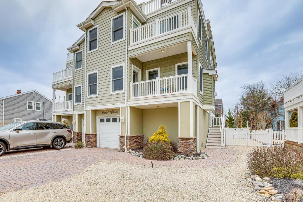 a house with a car parked in front of it at Long Beach Island Townhome with Rooftop Deck! in Long Beach