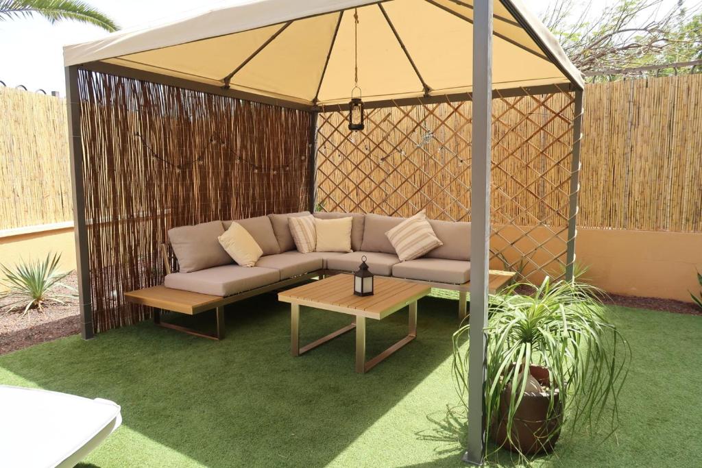 a couch in a gazebo with a table at Spacious apartment with large private garden in Palm Mar in Palm-Mar