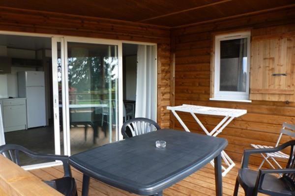 a patio with a table and chairs in a cabin at Chalet JACUZZI/spa privatif PERCE NEIGE in Plombières-les-Bains