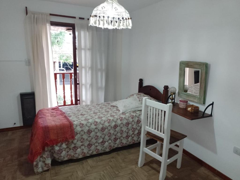 蒙特格蘭德的住宿－Casa Valeria, Ezeiza，卧室配有1张床、1张桌子和1把椅子