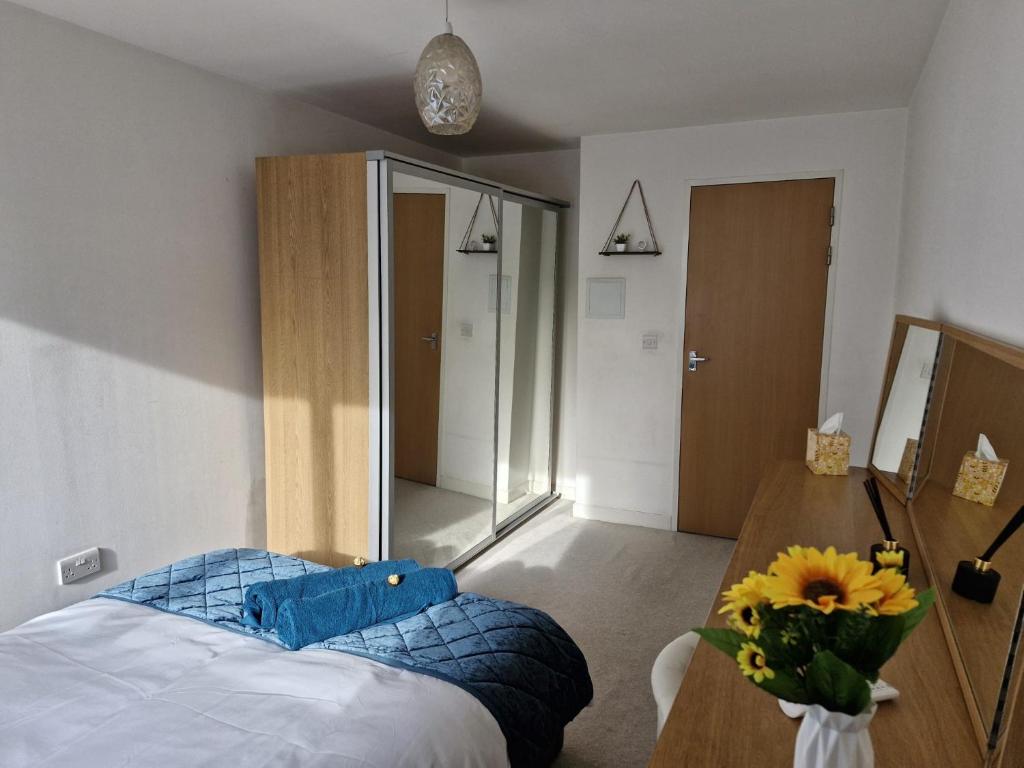 a bedroom with a bed and a table with a vase of flowers at Luxury Modern Central London - London Bridge - Westminster - 2 Bed Stylish Apartment in London