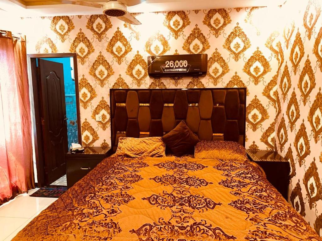 - une chambre avec un lit doté d'un couvre-lit orange dans l'établissement Sweet Homes Apartments, à Lahore
