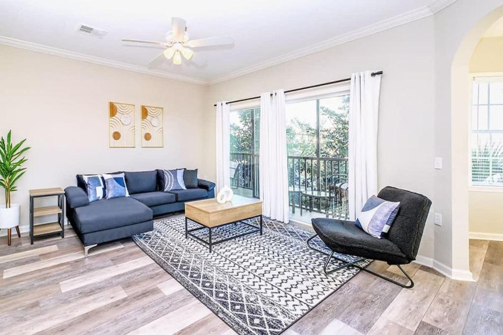 a living room with a blue couch and two chairs at Cozy 2BR Condo - Private Balcony - Near Disney in Orlando