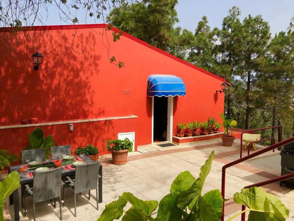 a red building with a table and chairs in front of it at Finca León in Santa Brígida