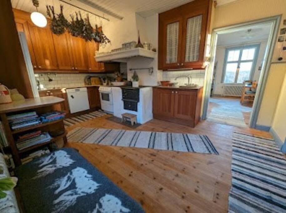 cocina grande con suelo de madera y electrodomésticos blancos en Hus i Edane, en Edane