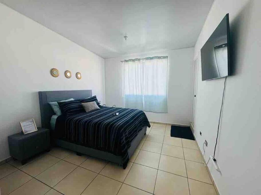 a bedroom with a bed and a flat screen tv at Modern Townhouse AC Wi-Fi full equipped Private in Santa Ana