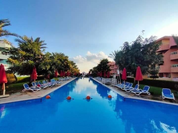 a large swimming pool with chairs and umbrellas at شاليه فندقي PORTO EL SOKHNA in Ain Sokhna