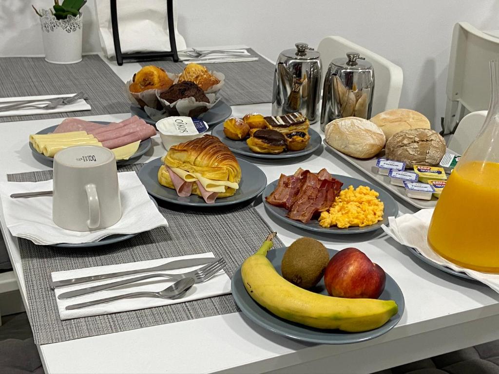 a table with many plates of food on it at Guest House Triunfo in Porto