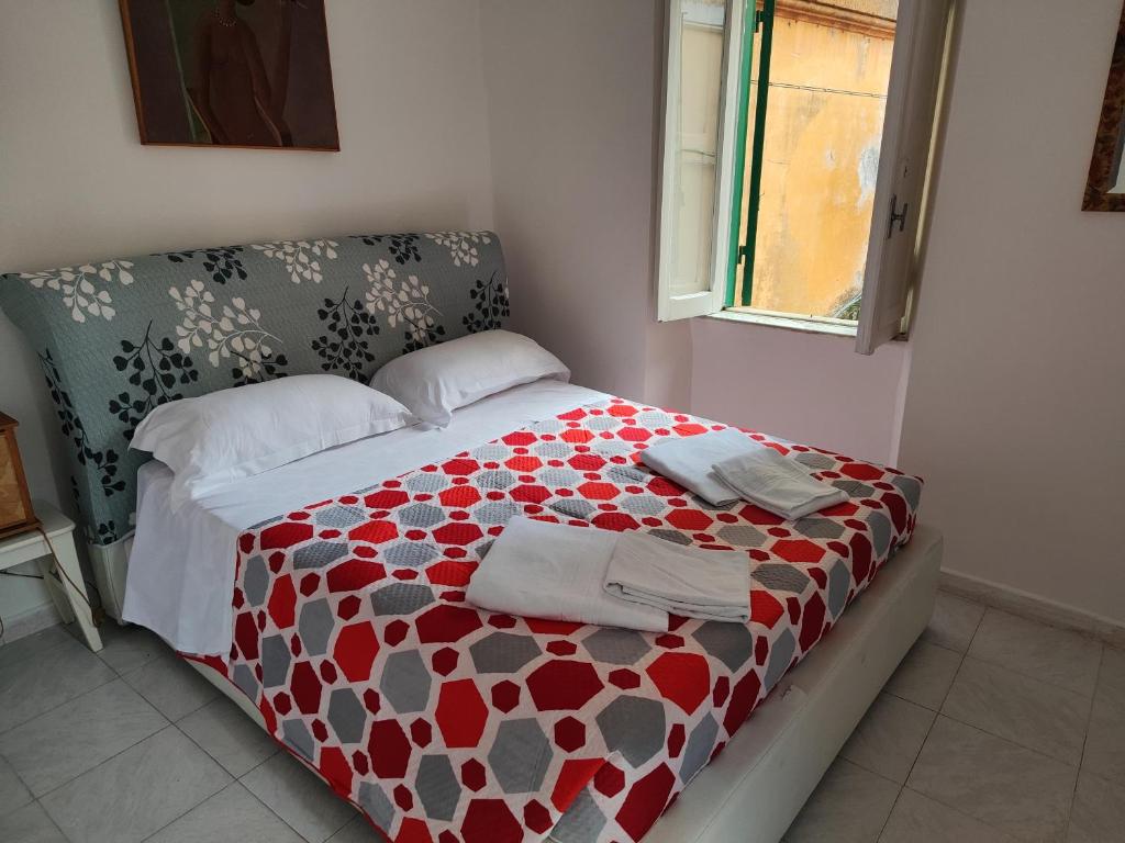 een slaapkamer met een bed met een rood en wit dekbed bij Casetta centro storico in Zagarolo