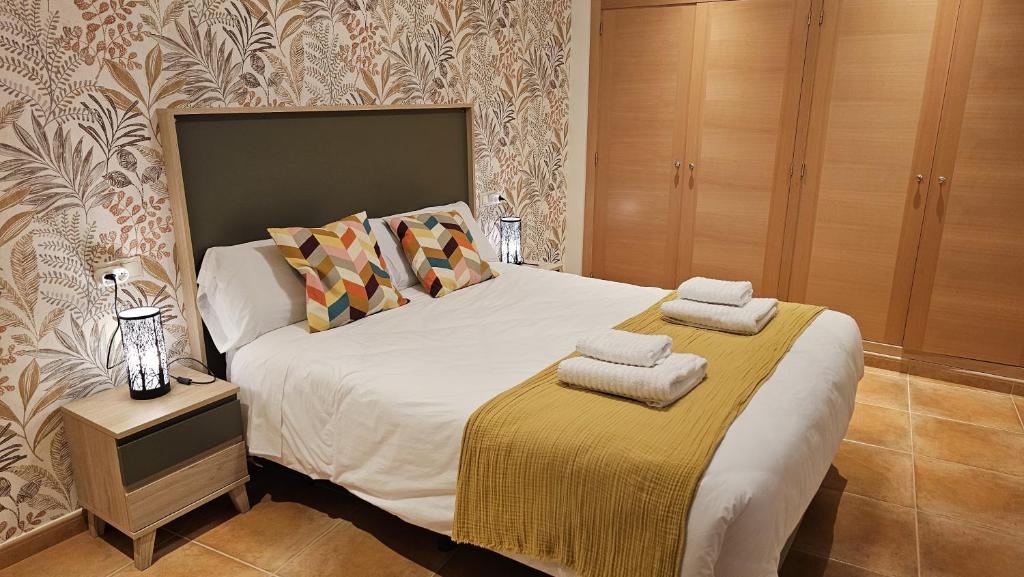 um quarto com uma cama e uma mesa de cabeceira com duas toalhas em Apartamento Cobre em Riópar