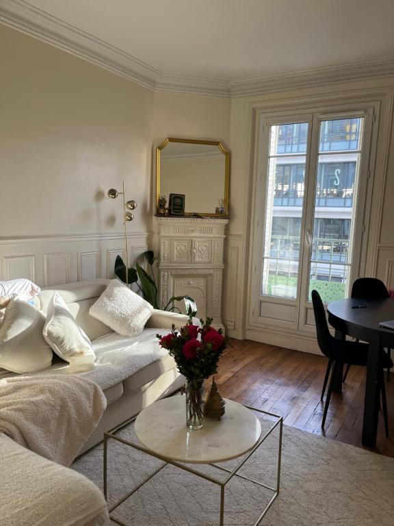 salon z kanapą i stołem z kwiatami w obiekcie Nice apartement near to Paris w mieście Neuilly-sur-Seine