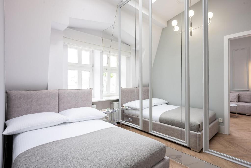a bedroom with two beds and a mirror at Native Apartments Starowiślna 43/16 in Krakow
