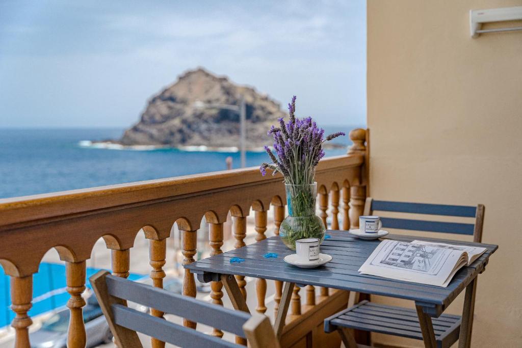 una mesa con un jarrón de flores en el balcón en BALCÓN DEL ATLÁNTICO, en Garachico