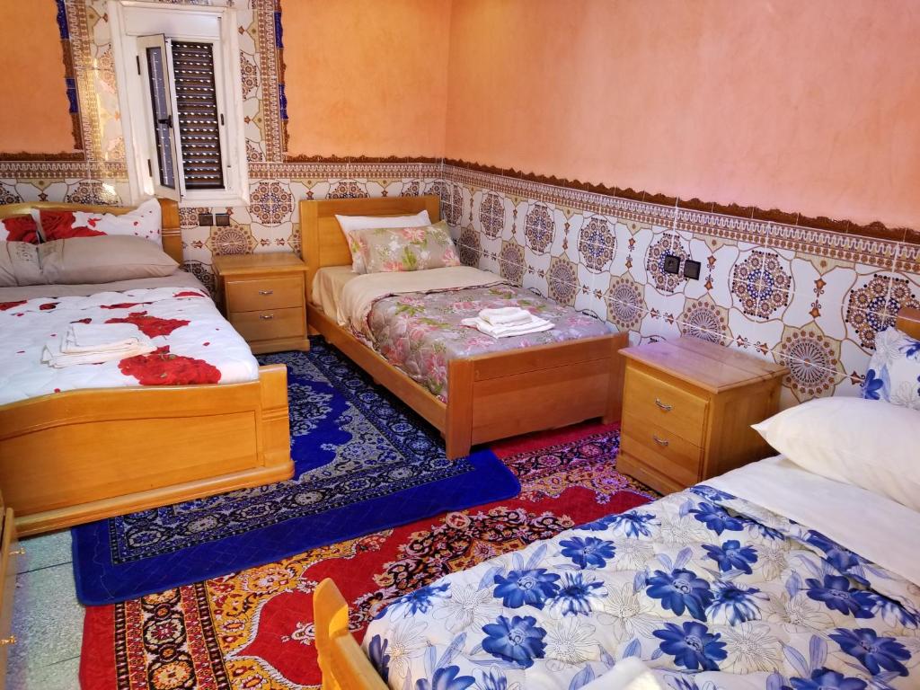 Zimmer mit 2 Betten und 2 Tischen in der Unterkunft Auberge Cascade Imilchil in Imilchil
