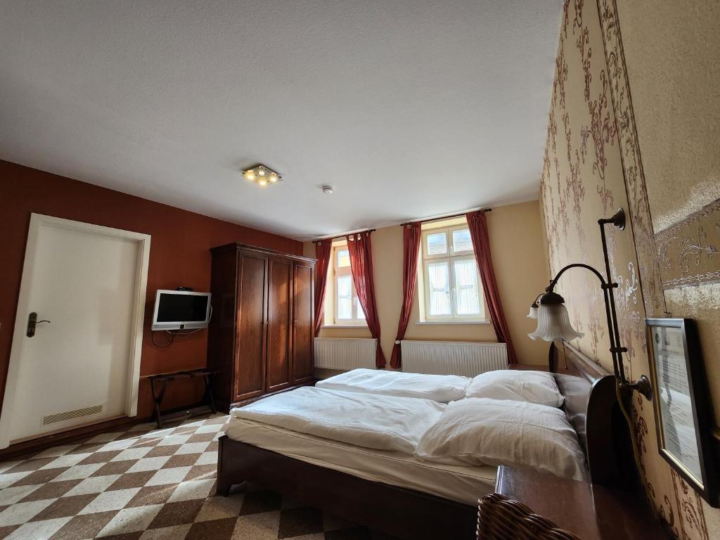 a bedroom with a large bed and a checkered floor at Hotel zur Post in Wernigerode