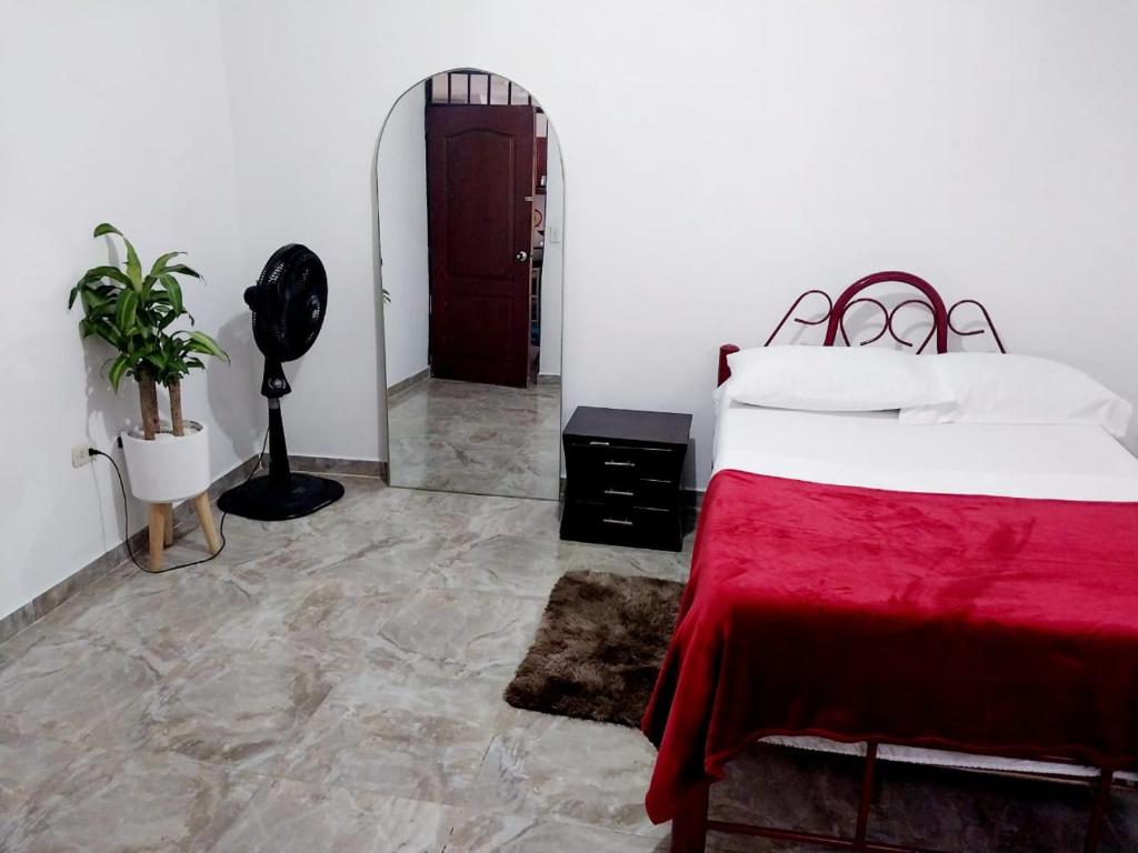 Un dormitorio con dos camas y una manta roja. en Habitación Cómoda en Familia, en Ibagué