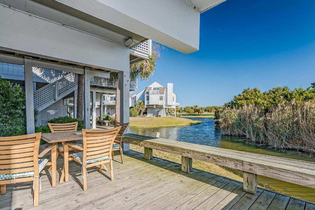 a wooden deck with chairs and a table and a river at Fenton House Villa BHI in Southport