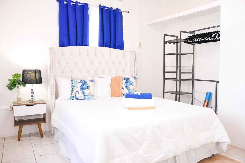 una camera da letto con un letto bianco con tende blu di The ARC 2 a Scarborough