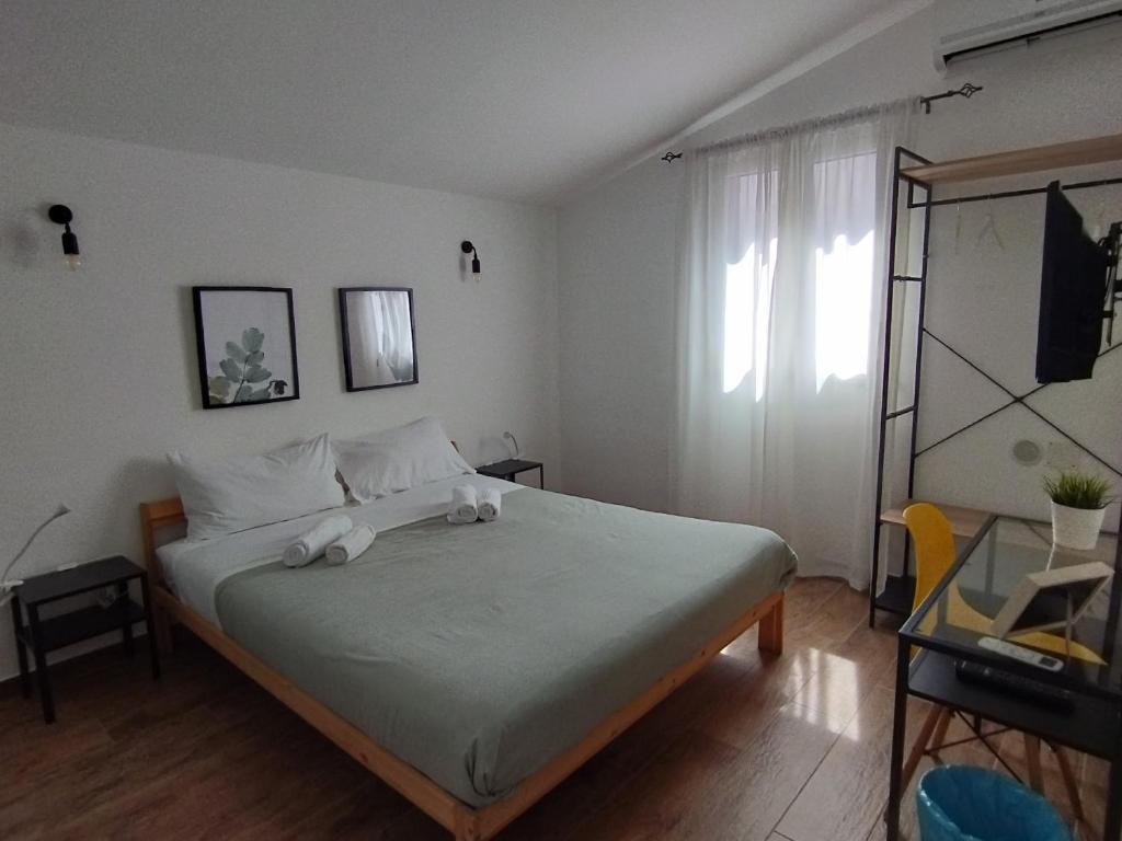 a bedroom with a bed with white sheets and a window at Triscele house in Palermo