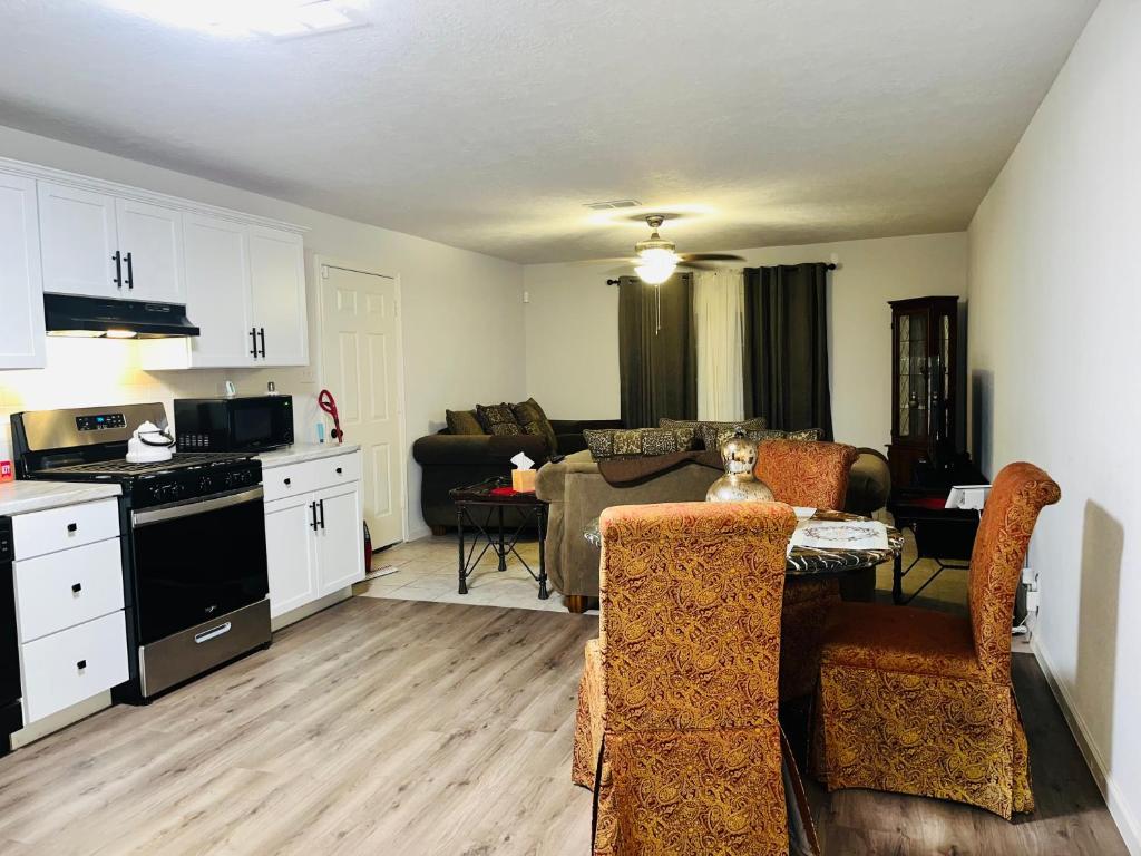 eine Küche und ein Wohnzimmer mit einem Sofa und einem Tisch in der Unterkunft Cozy and Convenient! in Port Arthur