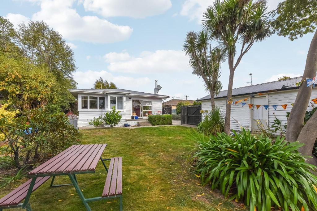 a house with a picnic table in the yard at Lush Oasis - Blenheim Holiday Home in Blenheim