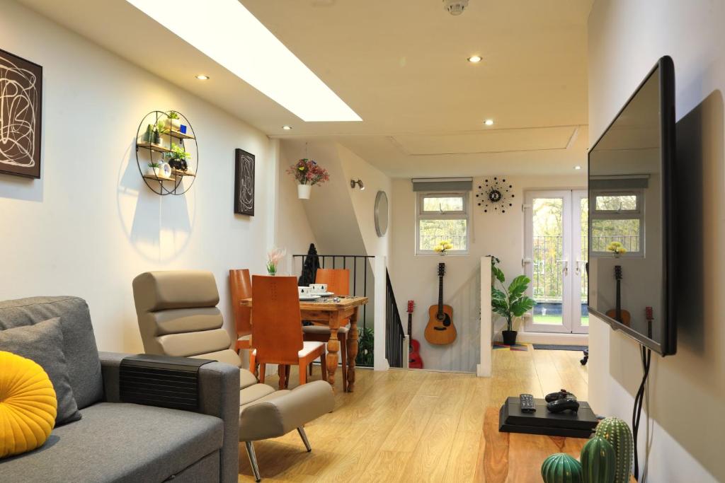 un soggiorno con divano e tavolo di Top Floor Apartment in Islington a Londra