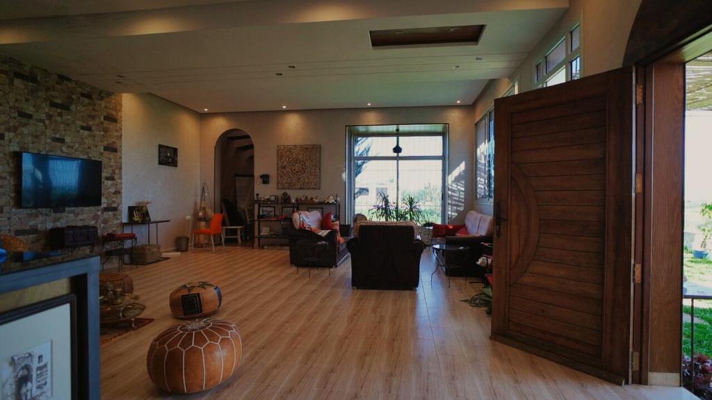 un soggiorno con pavimenti in legno e un soggiorno con camino. di jnan Lemonie a Asilah