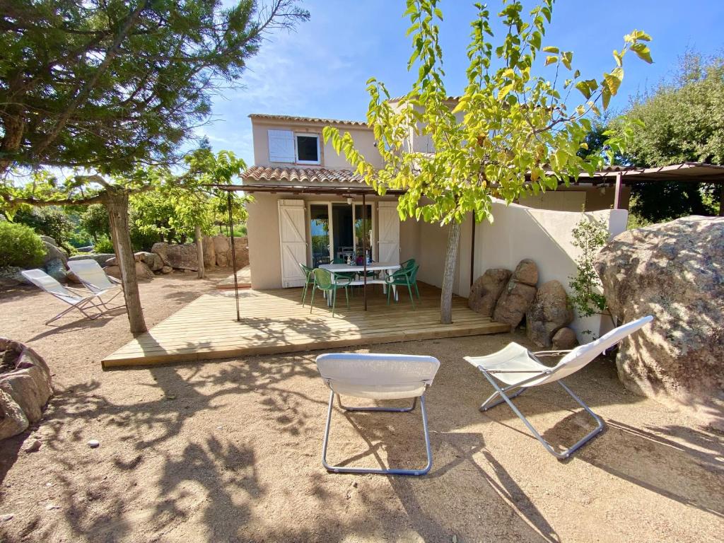 une arrière-cour avec des chaises et une table ainsi qu'une maison dans l'établissement Domaine de la Punta, à Porto-Vecchio