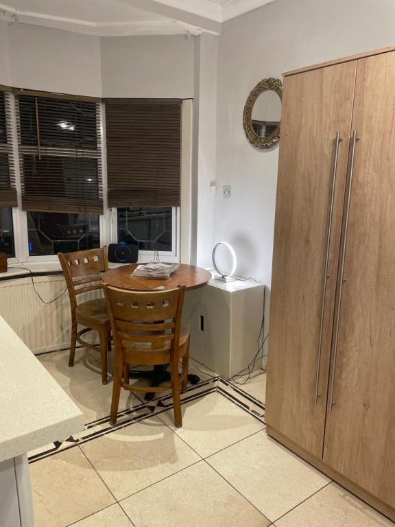 a kitchen with a table and chairs and a refrigerator at North London Studio Apartment in London