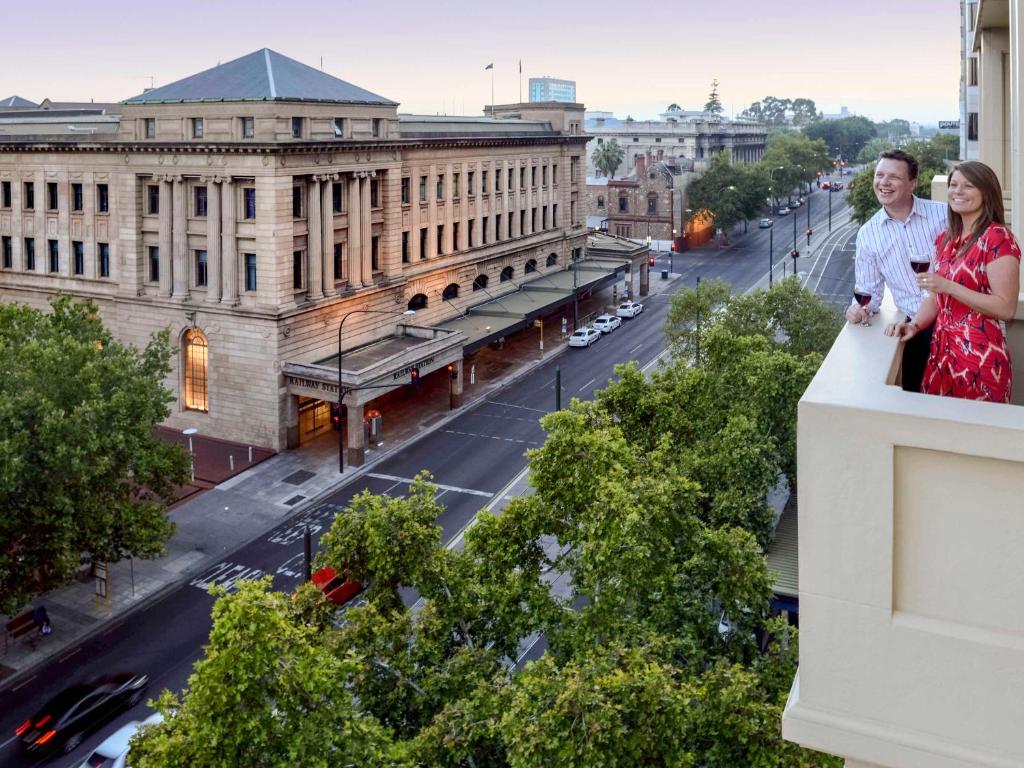 Grosvenor Hotel Adelaide في أديلايد: سيدتان واقفتان على حافة مبنى