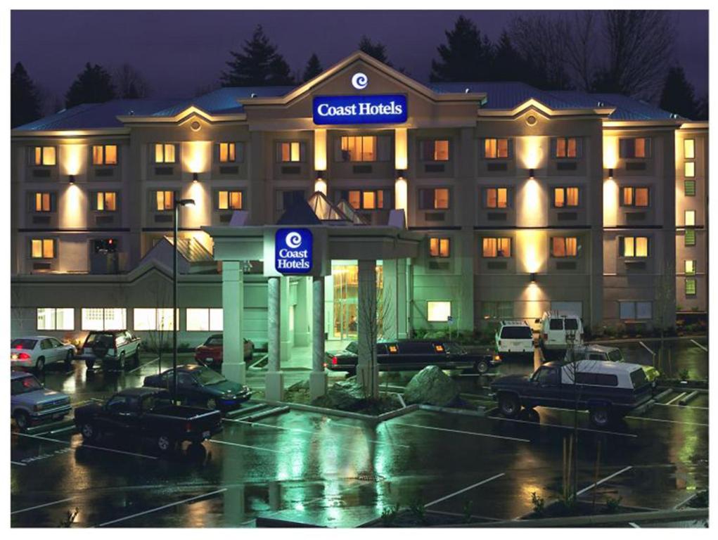 a hotel with cars parked in front of a parking lot at Coast Abbotsford Hotel & Suites in Abbotsford