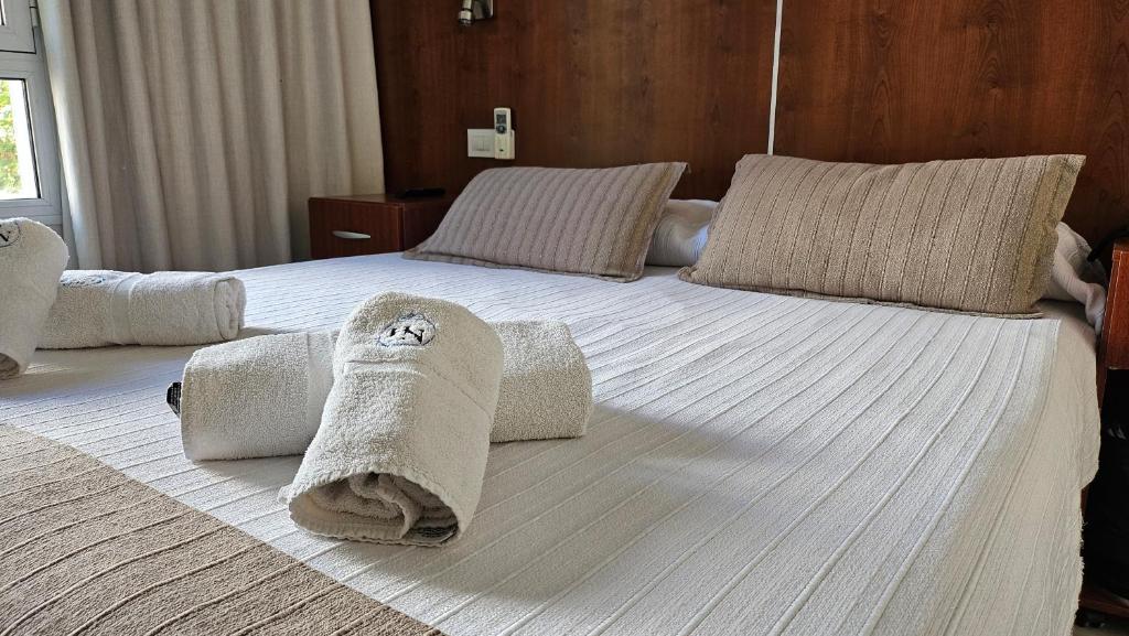 a large bed with towels and pillows on it at Hotel Novi in Mar del Plata