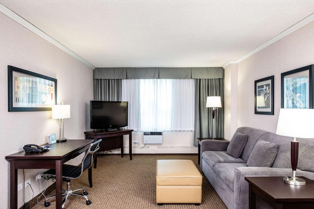a living room with a couch and a television at Campus Tower Suite Hotel in Edmonton