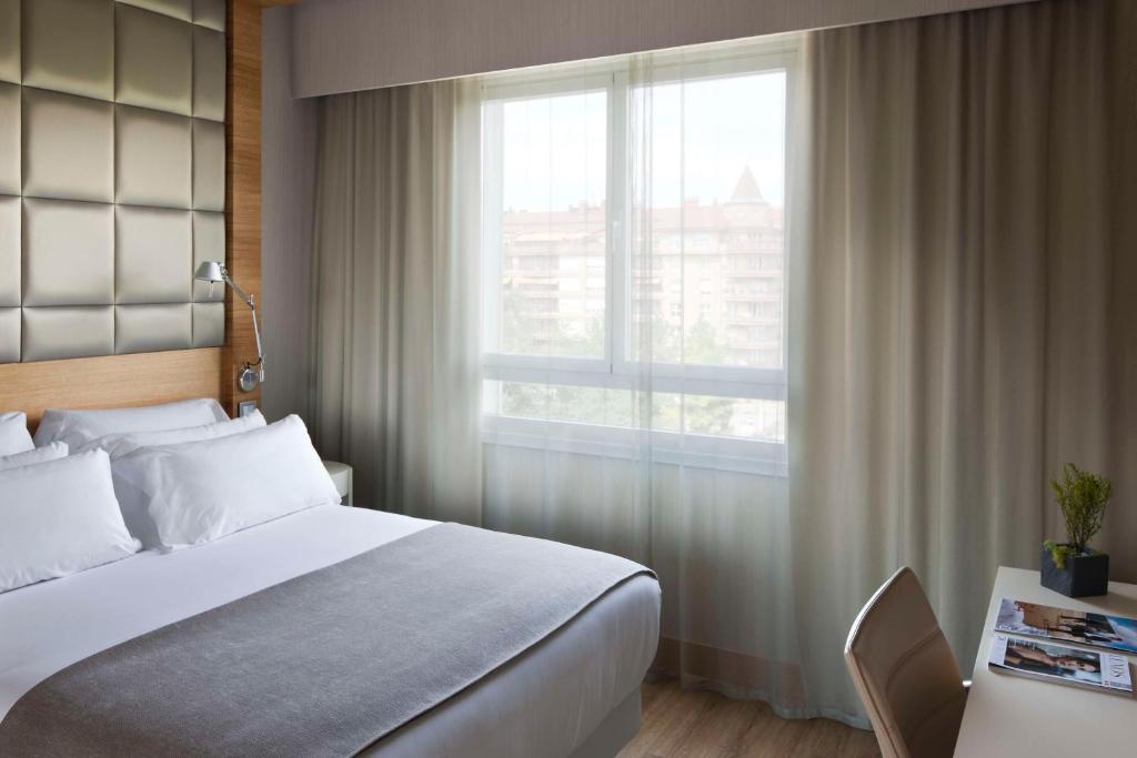 聖塞巴斯提安的住宿－柯萊克申聖塞巴斯蒂安阿蘭扎祖NH酒店，一间卧室设有一张大床和一个窗户。