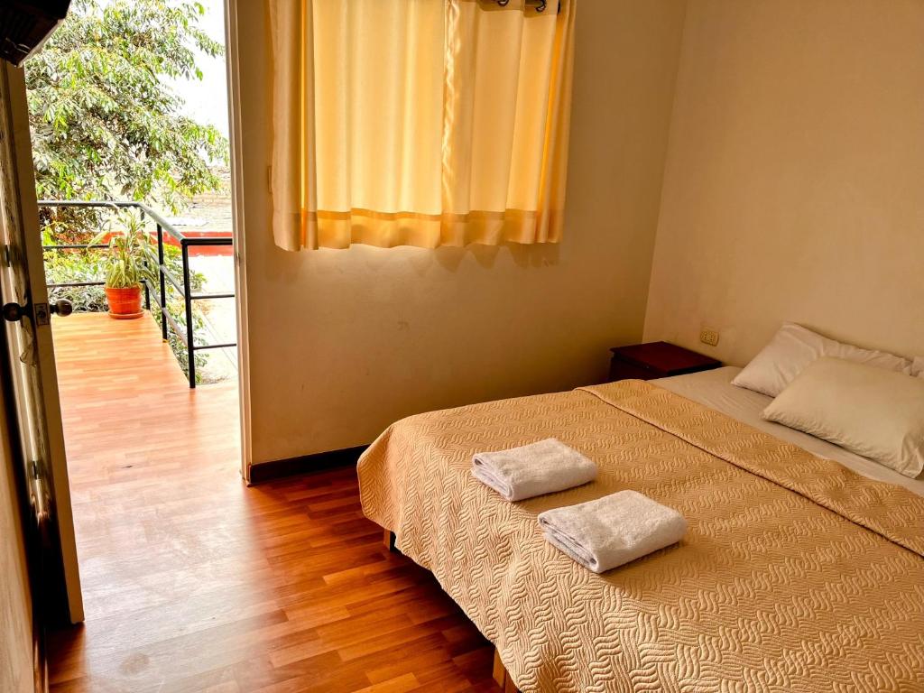 Un dormitorio con una cama con dos toallas encima. en Samanai Wasi Hostel, en Lima