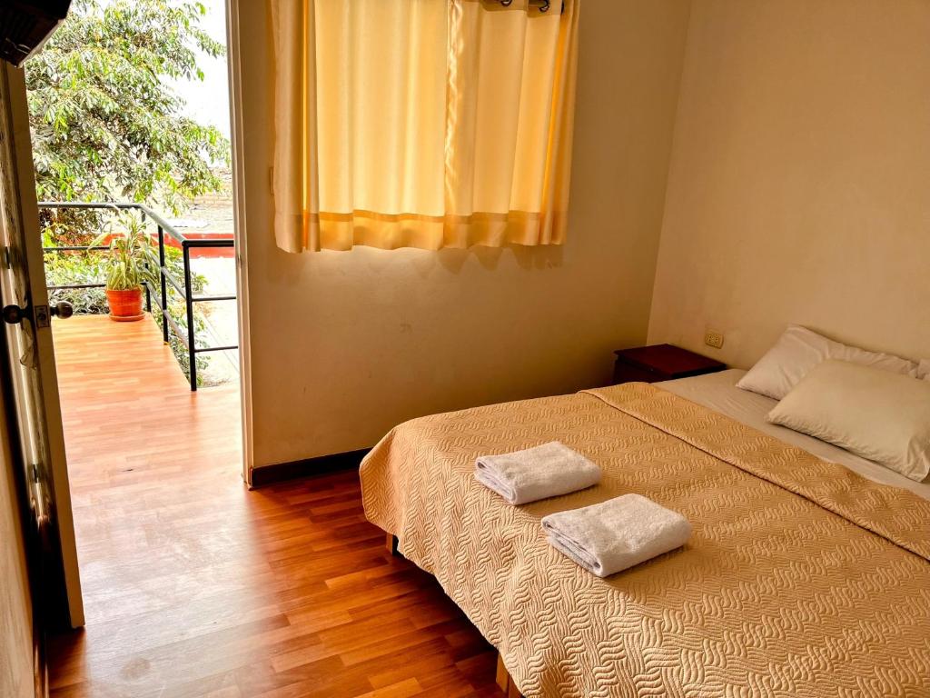 1 dormitorio con 1 cama con 2 toallas en Samanai Wasi Hostel, en Lima