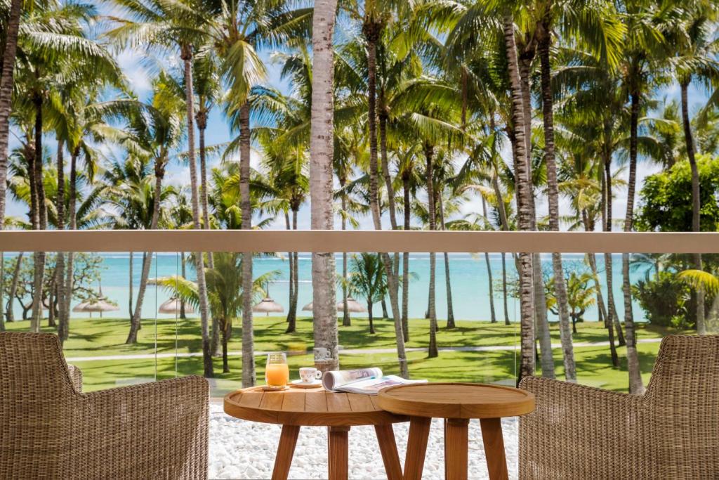 una mesa y sillas con vistas a las palmeras en One&Only Le Saint Géran, Mauritius en Belle Mare