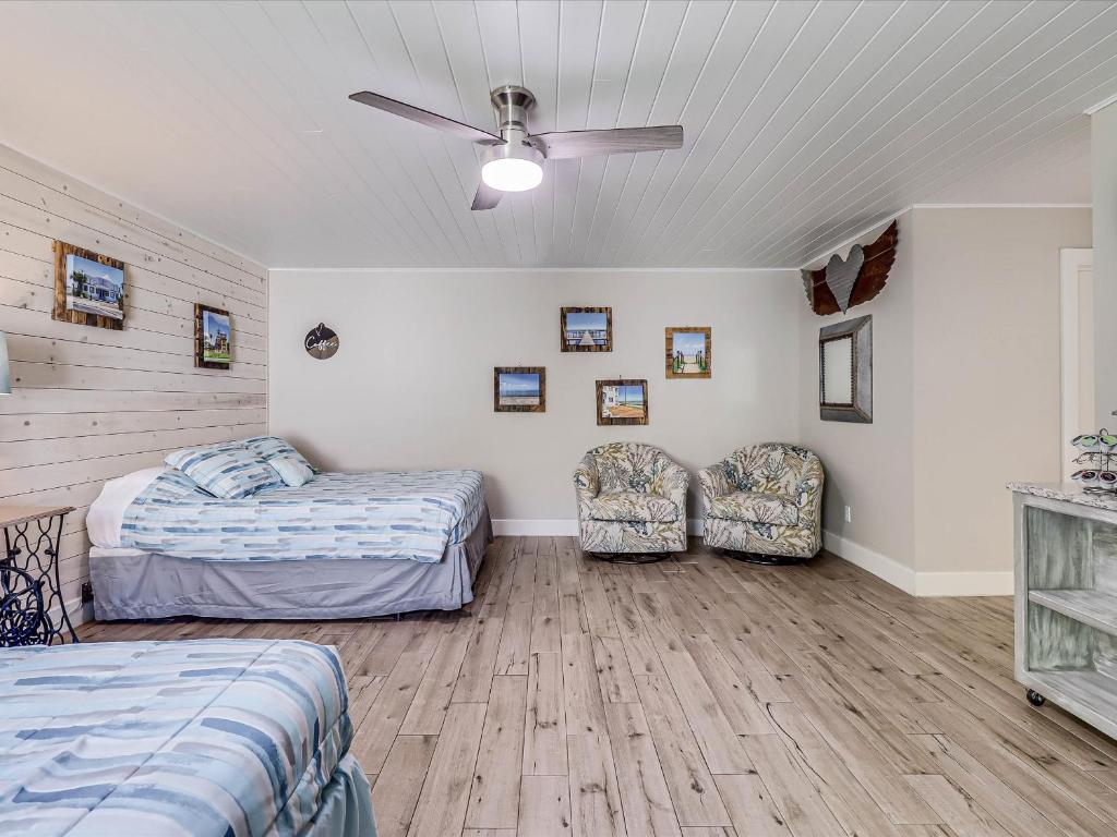 a bedroom with two beds and a ceiling fan at Oak Cottages 4 in Rockport