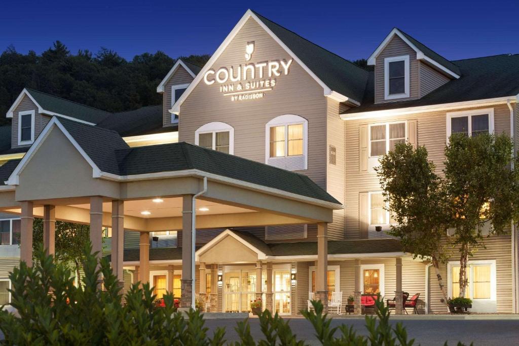 Country Inn & Suites by Radisson, Lehighton-Jim Thorpe, PA في Lehighton: مبنى فيه لافته مكتوب عليها نزل ريفي وموتيل