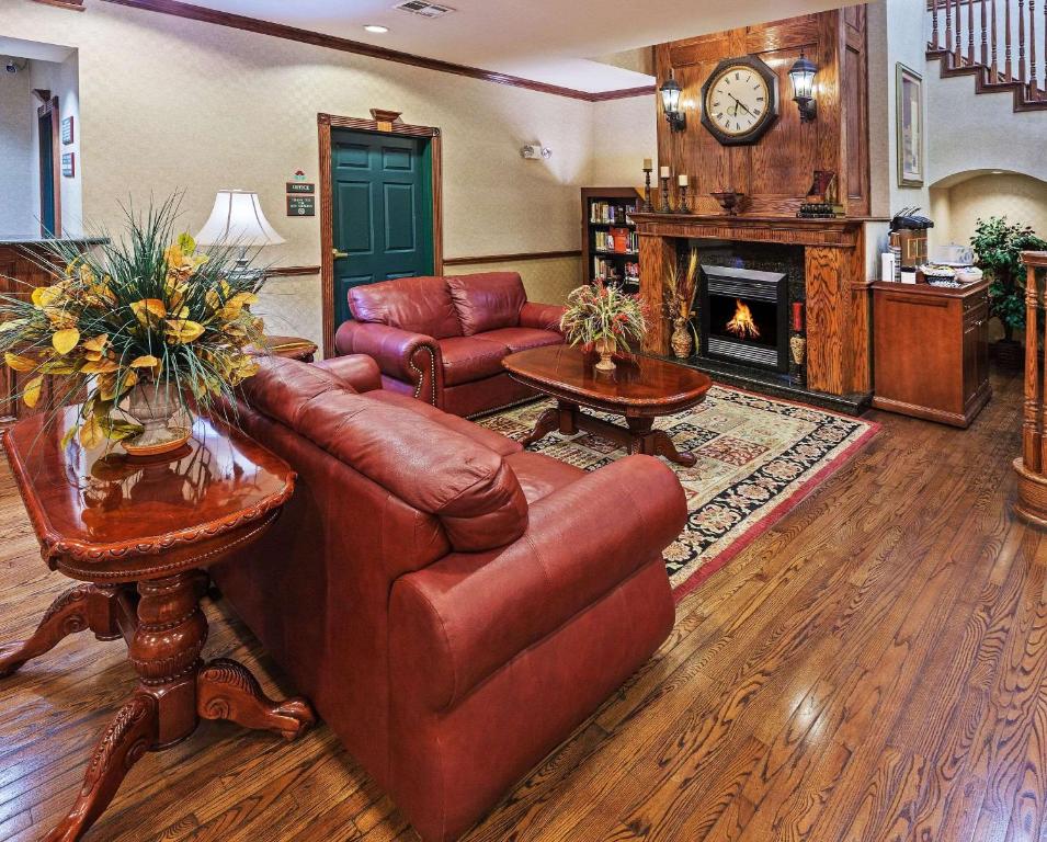 a living room with a leather couch and a fireplace at Country Inn & Suites by Radisson, Amarillo I-40 West, TX in Amarillo