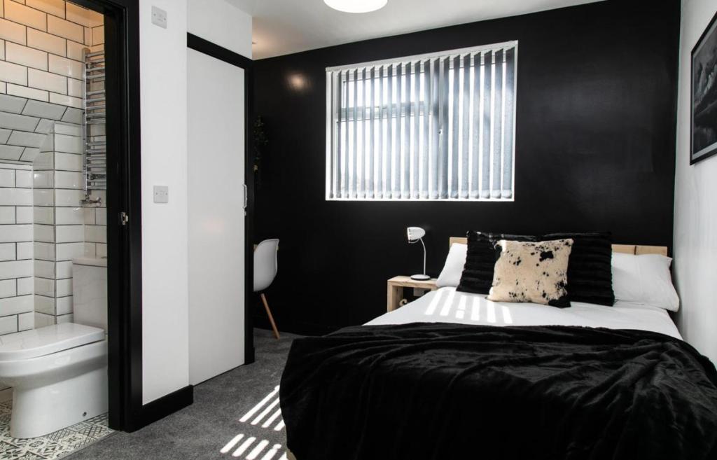a bedroom with black walls and a bed and a toilet at Room in a shared house Dean Street Coventry CV2 4FB in Coventry