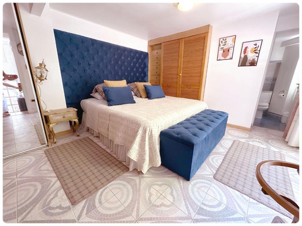 a bedroom with a large bed with a blue headboard at Apartamento loft Recoleta in Buenos Aires
