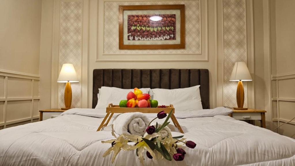 a bedroom with a bed with a tray of fruit on it at Peaceful in Heart of El mansoura in Mansoura