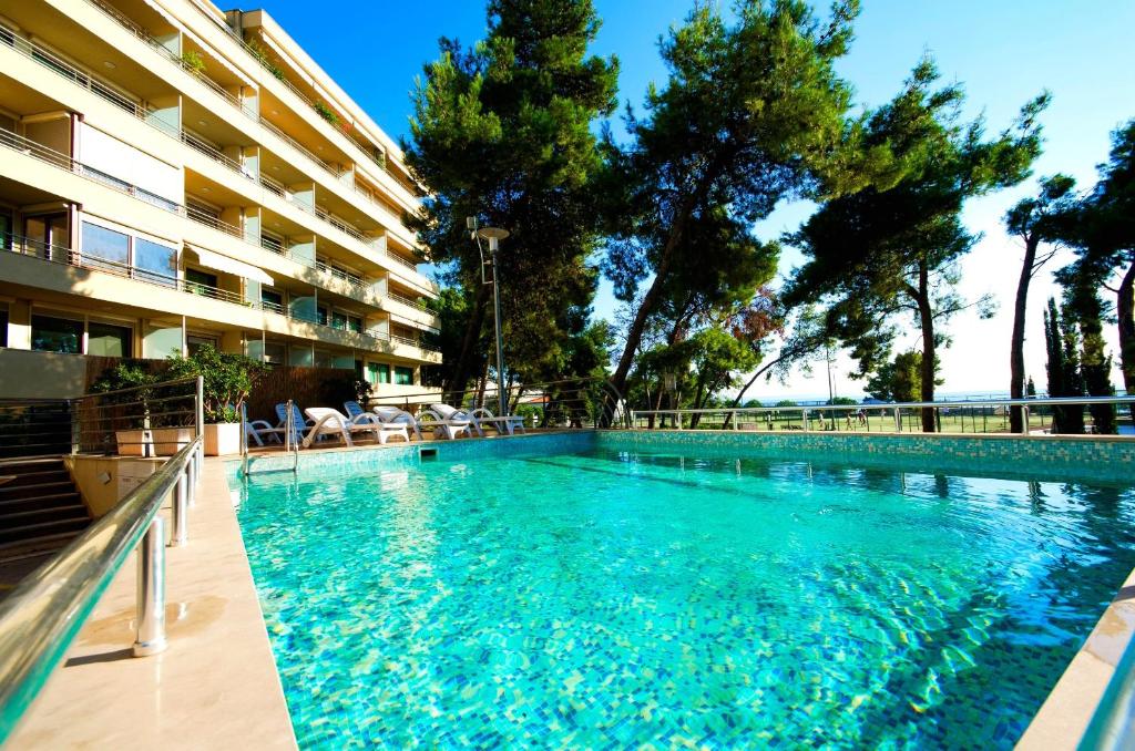 a swimming pool in front of a building at Apartments with a swimming pool Podstrana, Split - 20098 in Podstrana